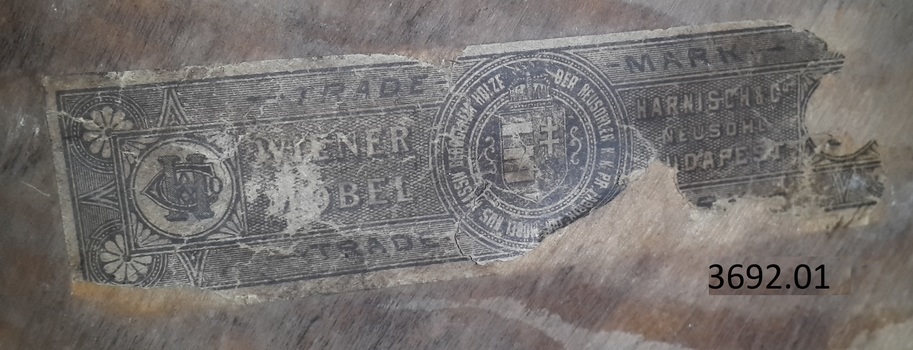 White paper label has black pattern and text plus symbols