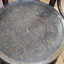 The round wooden seat has a carved floral pattern
