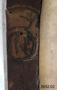The letter 'N' is stamped inside a circle that is below the outline of a crown