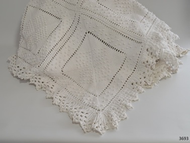 White crochet bedspread with worked squares and lace-like edging