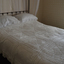 White crochet bedspread covers the double bed and down the sides