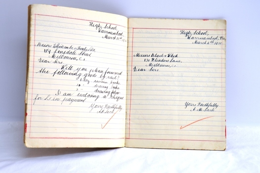 Printed and ruled lines on pages with handwritten script notes and correction ticks