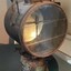 Mounted lamp has metal brackets with wooden handles, one on each side of lamp