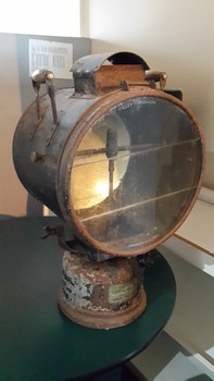 Mounted lamp has metal brackets with wooden handles, one on each side of lamp