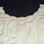 Cream embroidery with yellow highlights. Edges of garment are crocheted