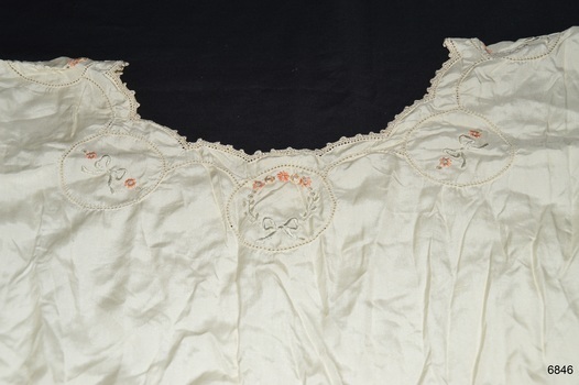 Cream embroidery with yellow highlights. Edges of garment are crocheted
