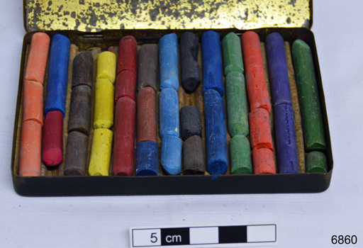 Coloured pastels within a storage tin
