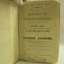 Book open at fly page; white page with black print and stamp