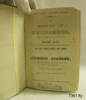 Book open at fly page; white page with black print and stamp