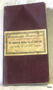 Maroon covered book with cream coloured label pasted on the front, printed and hand written details on label.