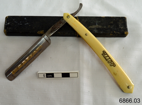 Razor is half opened, showing inscriptions on the blade and handle