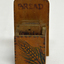 A wooden container holding five wooden tiles 
