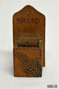 A wooden container holding five wooden tiles 