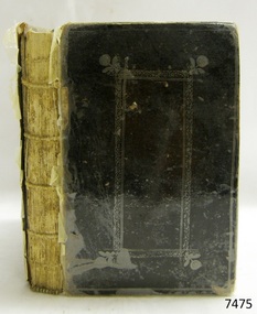 Black hardcover book with embossed border on front cover, spine not covered
