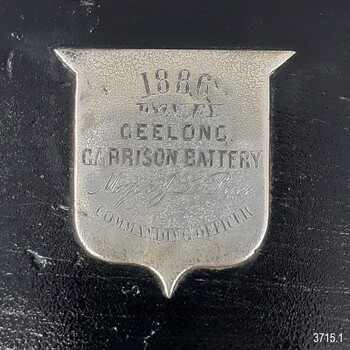 Silver shield with engraved text, mounted on the black plinth