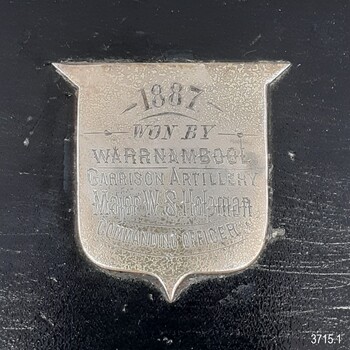 Silver shield with engraved text announcing the winner