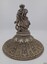 The figure on the lid is holding a wreath in each hand and appears to be bowling it