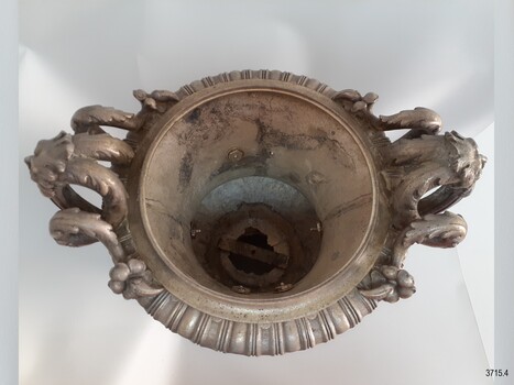 Inner surface of the trophy is rough, has a metal brace across the centre and bolts and washers on the sides