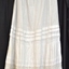 Long petticoat, soft pleats at waist, fabric tie at back of waist, pin tucks around skirt, lace trim.