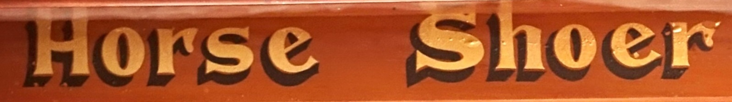 Text in gold leaf advertises the maker's trade