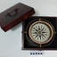 Navigation compass withing the base of a wooden box, with lid beside it