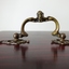 Brass swing handle with decorative design.