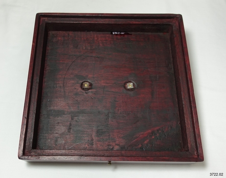Lid has fitted edges and brass fixtures in centre
