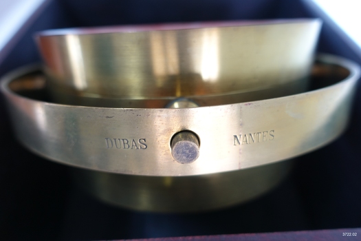 Side of metal compass, showing inscriptions