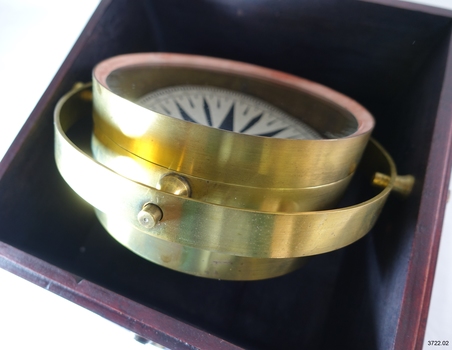Compass is tilted in its base, resting on its gimval ring