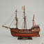 Ship model mounted on a wooden stand, flying a coloured flag