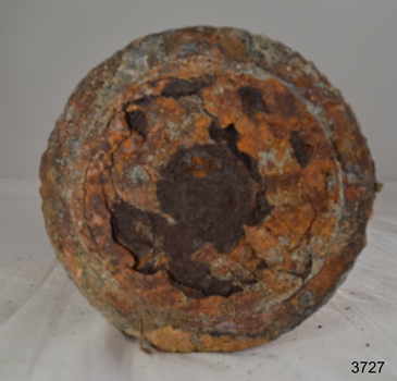 Round base is corroded and metal has flaked away