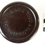 A small bottle of ink, sitting in a brown Bakelite screw top container, designed to protect it during travel.