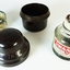 A small bottle of ink, sitting in a brown Bakelite screw top container, designed to protect it during travel.