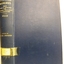 Blue cloth hardcover book with embossed lines and text on the spine