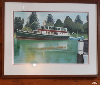 Steamship on calm water, trees in background, small vessel in foreground.