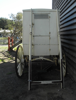 Rear of baker's card showing door and equipment for attaching to a horse