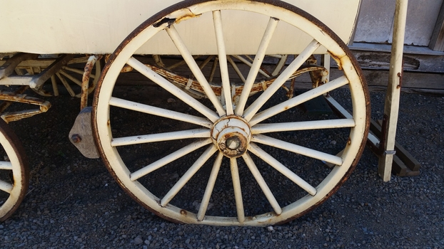 The large wheels have sixteen spokes. Below the body are leaved springs for suspension.