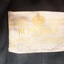 Light coloured label with embroidered gold thread and handwritten details