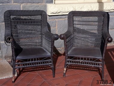 Front of two upright wicker chairs painted black