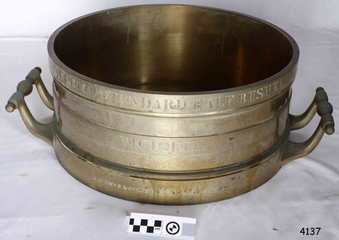 Brass cylinder with handles and engraved text