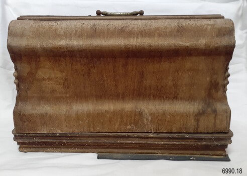 Case has shaped sides and fancy work on the ends, with a metal handle on top