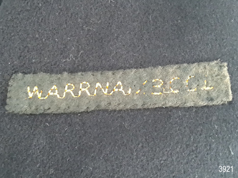 Label is hand stitched onto jacket and has text 'WARRNAMBOOL' embroidered in gold