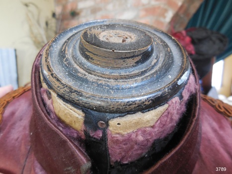 Neck area is filled in with wooden shape that has concentric rings