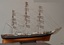 Three-masted ship. White figurehead. Black with white stripes on hull.