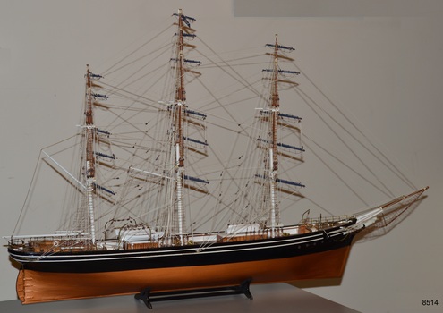Three-masted ship. White figurehead. Black with white stripes on hull.