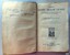 Title page has text and logo, facing page has handwritten inscriptions