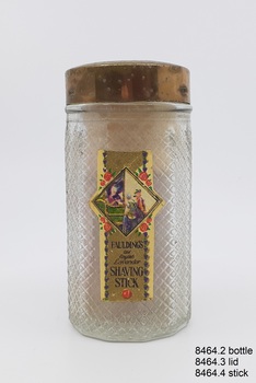 Textured glass bottle with gold-coloured metal lid and paper label fixed to one side