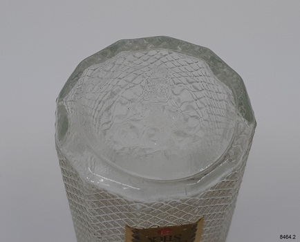 Twelve-sided glass bottle with embossed symbol and text
