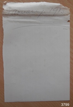 Note paper with crumpled top edge, with text "January 1915" written in pencil and underlined