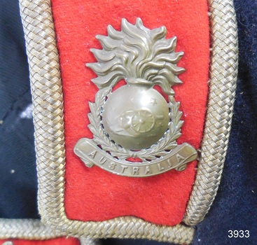 Badge is overall shape of a hand grenade with a field cannon and stars on it and the word 'Australia' below